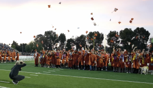 members of castaic highschool throwing their caps off in celebration for their graduating accomploshment